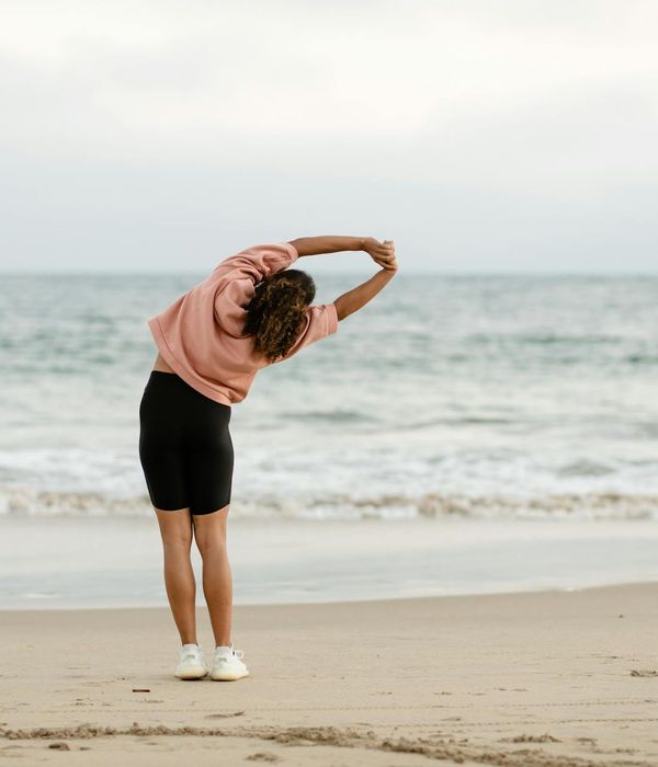 Person stretching outdoors during a beautiful sunset, feeling energized.