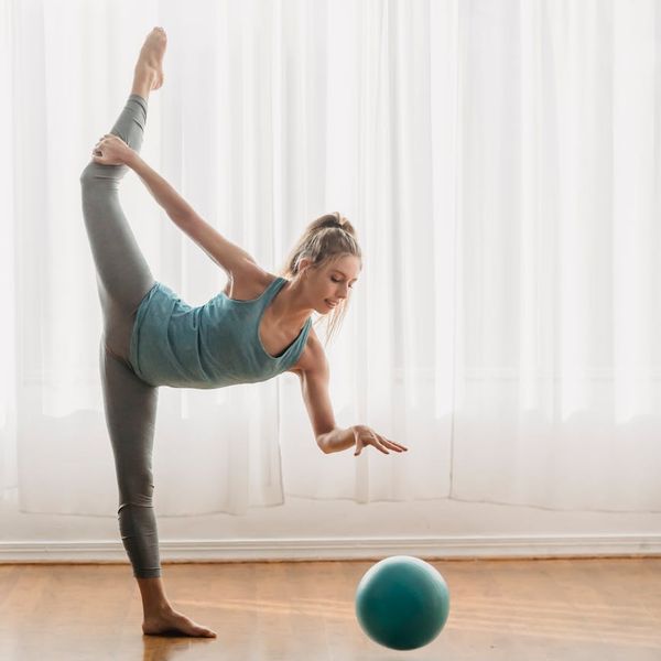 Woman performing a graceful yoga pose in a bright, calm room.